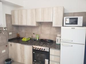 Una cocina con estufa y refrigerador blanco. en ALTOS DE ALEM, en Alta Gracia 9 fotos más