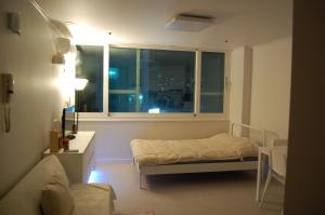 um pequeno quarto com uma cama e uma janela em Newly Renovated House in Yatap-dong em Seongnam