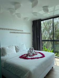 a bedroom with a bed with a flower arrangement on it at Baan Saint-Tropez Seaview Villas Kata Beach in Kata Beach