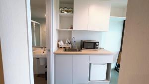 a kitchen with a counter with a microwave and a sink at Resort Style Condo Suksawat 64 Bangkok ND in Ban Tha Hin