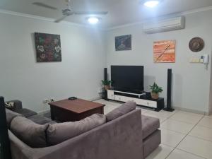 a living room with two couches and a flat screen tv at Dashwood Dreaming - Room in Shared Apartment in Darwin