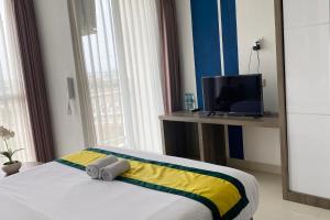 um quarto de hotel com uma cama e uma televisão em Hotel Dhika Serenity Surabaya em Surabaya