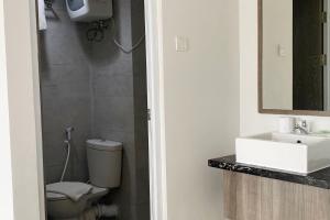 a bathroom with a toilet and a sink at Hotel Dhika Serenity Surabaya in Surabaya