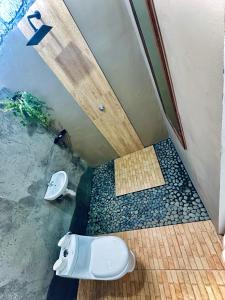 a bathroom with a shower with a toilet in it at Ijen Backpacker in Banyuwangi