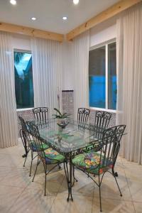 a dining room with a glass table and chairs at Palacio Pura Vibra in Ciudad Cariari