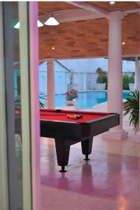 a pool table in a room with a swimming pool at Palacio Pura Vibra in Ciudad Cariari