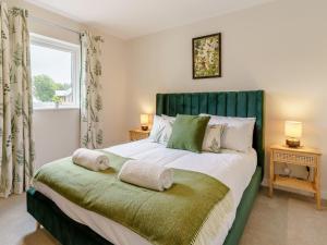 um quarto com uma cama grande e uma cabeceira verde em 2 Bed in Gower 91725 