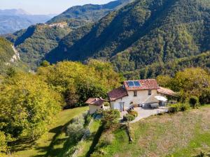 uma casa numa colina com montanhas ao fundo em Belvilla by OYO Buffardello del Colle em Fornovolasco