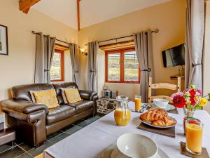 a living room with a leather couch and a table at 1 Bed in Boscastle LPENC in Boscastle