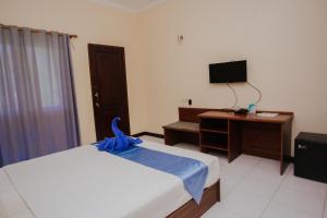 a bedroom with a bed and a desk and a television at Medana Bay Marina in Paloh