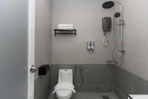 een badkamer met een douche, een toilet en een telefoon bij Hotel Luma Senawang in Seremban