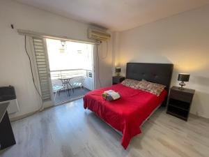 1 dormitorio con cama roja y ventana grande en Beautiful Apartment in the Best Area of Congreso en Buenos Aires