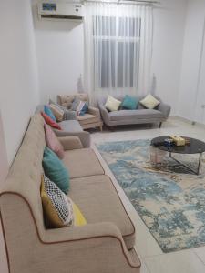 ein Wohnzimmer mit einem großen Sofa und einem Tisch in der Unterkunft شقة السلمة أم القيوين in Umm al-Qaiwain
