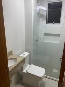 a bathroom with a shower and a toilet and a sink at Ótimo Ap a 50m da areia Churrasq 2Q 2banheiros in Torres