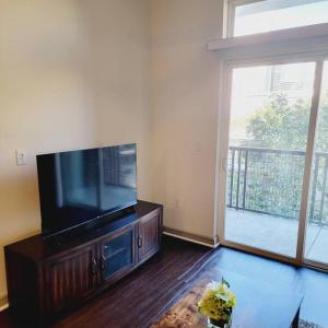 a living room with a flat screen tv and a large window at Downtown Dream Toyota Ctr/George R Brown/Minute Maid Stadium in Houston