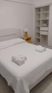 um quarto com uma cama com toalhas brancas em Los Juncos Jujuy em San Salvador de Jujuy