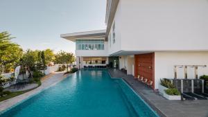 a swimming pool in front of a building at La Vie Hotel Juru in Simpang Ampat