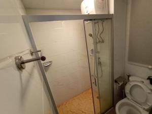a bathroom with a shower and a toilet at Sky House BSD 2 Bedrooms by Shinzhouz in Tjilandak