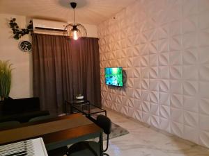 TjilandakにあるSky House BSD 2 Bedrooms by Shinzhouzのリビングルーム(ソファ、壁掛けテレビ付)