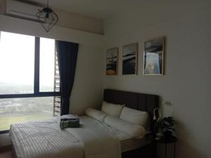 a bedroom with a bed and a large window at Sky House BSD 2 Bedrooms by Shinzhouz in Tjilandak