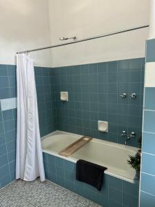 a blue tiled bathroom with a bath tub at Thommos Pub in Cobden