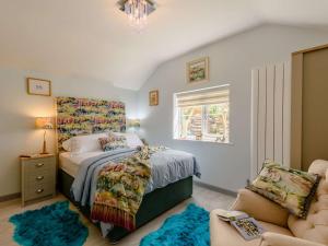 a bedroom with a bed and a chair and a window at 2 Bed in Lixwm 88028 in Nannerch