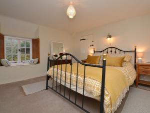 a bedroom with a bed with a yellow bedspread at 2 Bed in Chideock DC194 in Chideock