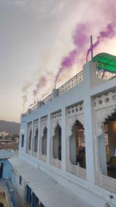 een wit gebouw met een zonsondergang op de achtergrond bij Hotel Bharatpur Palace in Pushkar