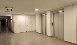 un corridoio con armadietti bianchi in un edificio di Bonito departamento amoblado ubicado en la comuna de San Miguel a Santiago