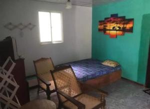 a room with a bed and chairs and a window at Vintage River View Villa in Panadura