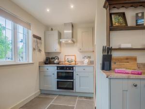 a kitchen with white cabinets and a stove at 2 Bed in Ravenstonedale SZ141 in Ravenstonedale