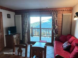 salon z czerwoną kanapą i balkonem w obiekcie Résidence Roselend - Charmant appartement de 3 pièces situé dans une résidence au village du Chantel, proche des pistes et avec piscine. MAE-2474 w mieście Arc 1800