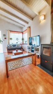 een woonkamer met een tafel en een tv bij Lafken Lodge in Villarrica