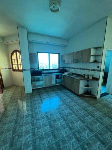 a large kitchen with a blue tile floor at Hermoso PH con parrillera in La Victoria
