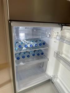 um frigorífico aberto cheio de garrafas de água em Country Complex Bangna em Bangkok