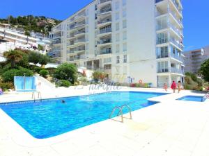 a swimming pool in front of a building at Apartamento Roses, 2 dormitorios, 4 personas - ES-228-152 in Roses