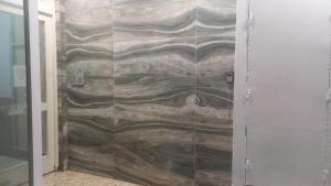 a shower with a stone wall in a bathroom at Plaza Libertad in Santiago del Estero