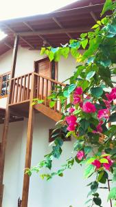 einen Balkon eines Hauses mit rosa Blumen in der Unterkunft Nueva Tierra, Ayampe in Las Tunas