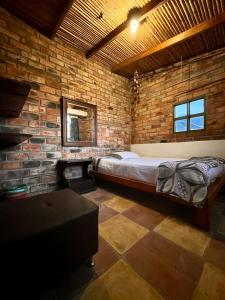 a bedroom with a bed and a brick wall at Ventanas Parapente Boutique - Club House in El Cerrito