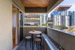 a balcony with a small table and stools at Cyclinn Berrini in Sao Paulo