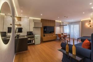 a living room with a blue couch and a television at Cyclinn Berrini in São Paulo