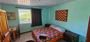 een slaapkamer met een bed en een raam erin bij Akivai Lodge - Maison de vacance Ua-Pou Marquises in Hakamui