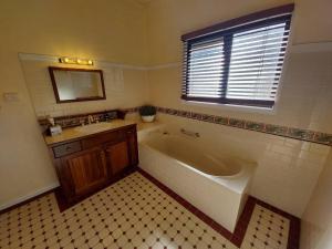 y baño con bañera, lavabo y espejo. en Amaroo House 'A beautiful place!', en Lyra