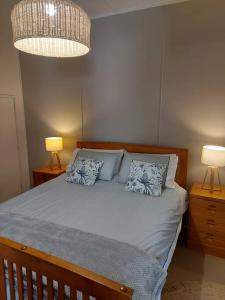 1 dormitorio con 1 cama con 2 mesitas de noche y 2 lámparas en Amaroo House 'A beautiful place!', en Lyra