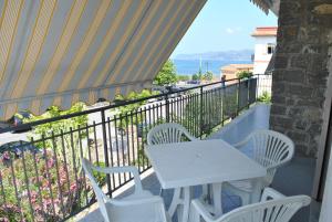 un tavolo bianco e sedie sul balcone di Villa Gentile ad Acciaroli
