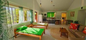 ein Wohnzimmer mit einem Sofa und einer Küche in der Unterkunft Akivai Lodge - Maison de vacance Ua-Pou Marquises in Hakamui