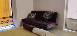 a brown couch sitting in a room with a rug at Bonito y cómodo apartamento in Sucre
