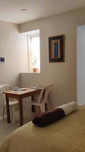 a bedroom with a desk and a table and a window at Bonito y cómodo apartamento in Sucre