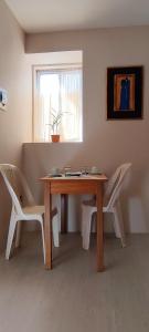 uma mesa de madeira com 2 cadeiras e uma janela em Bonito y cómodo apartamento em Sucre