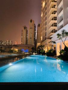 a large swimming pool in a city at night at Designer Suite Quill Residence by Hausome in Kuala Lumpur